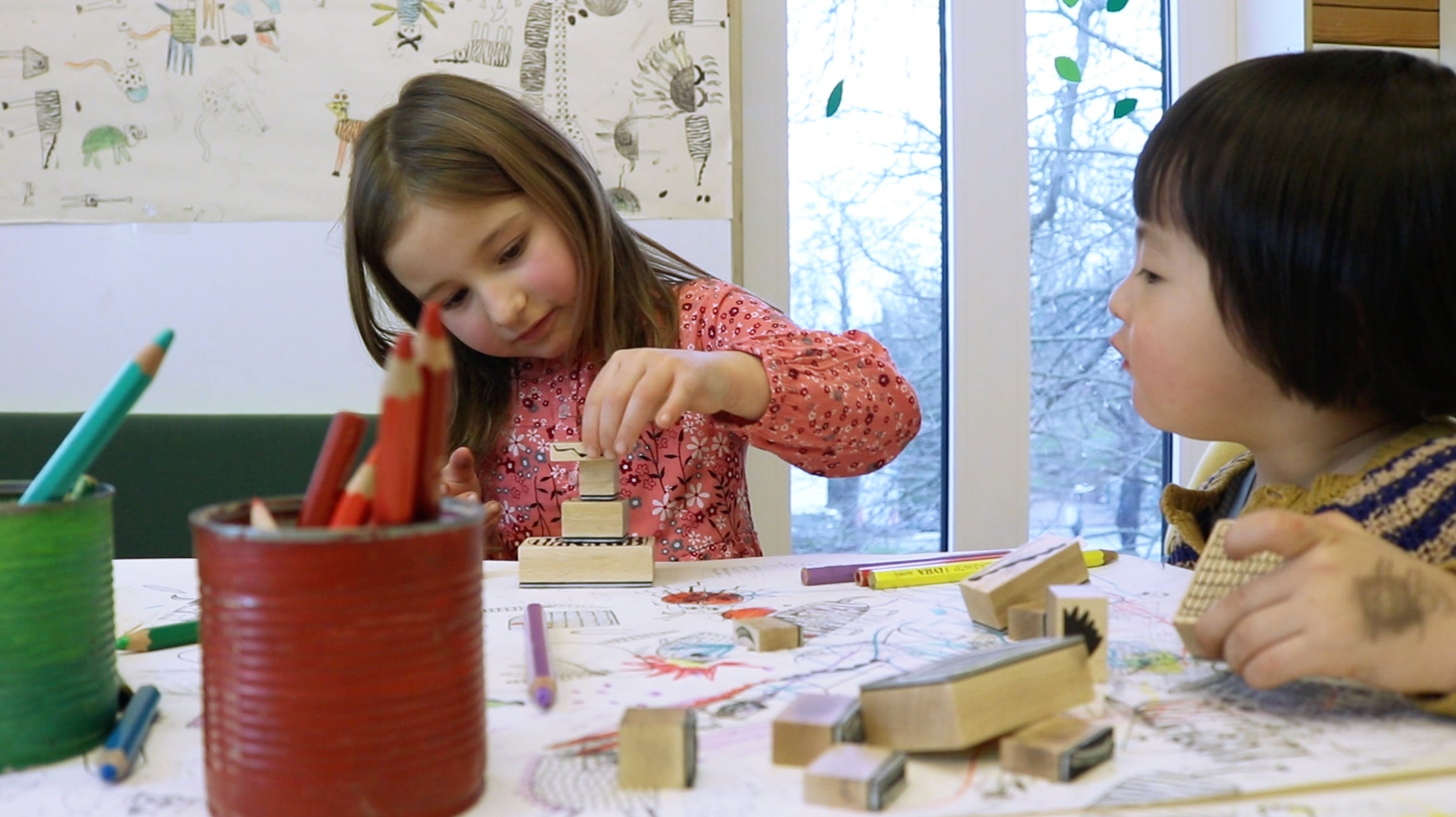 Kinder stapeln Stempel an einem Tisch.