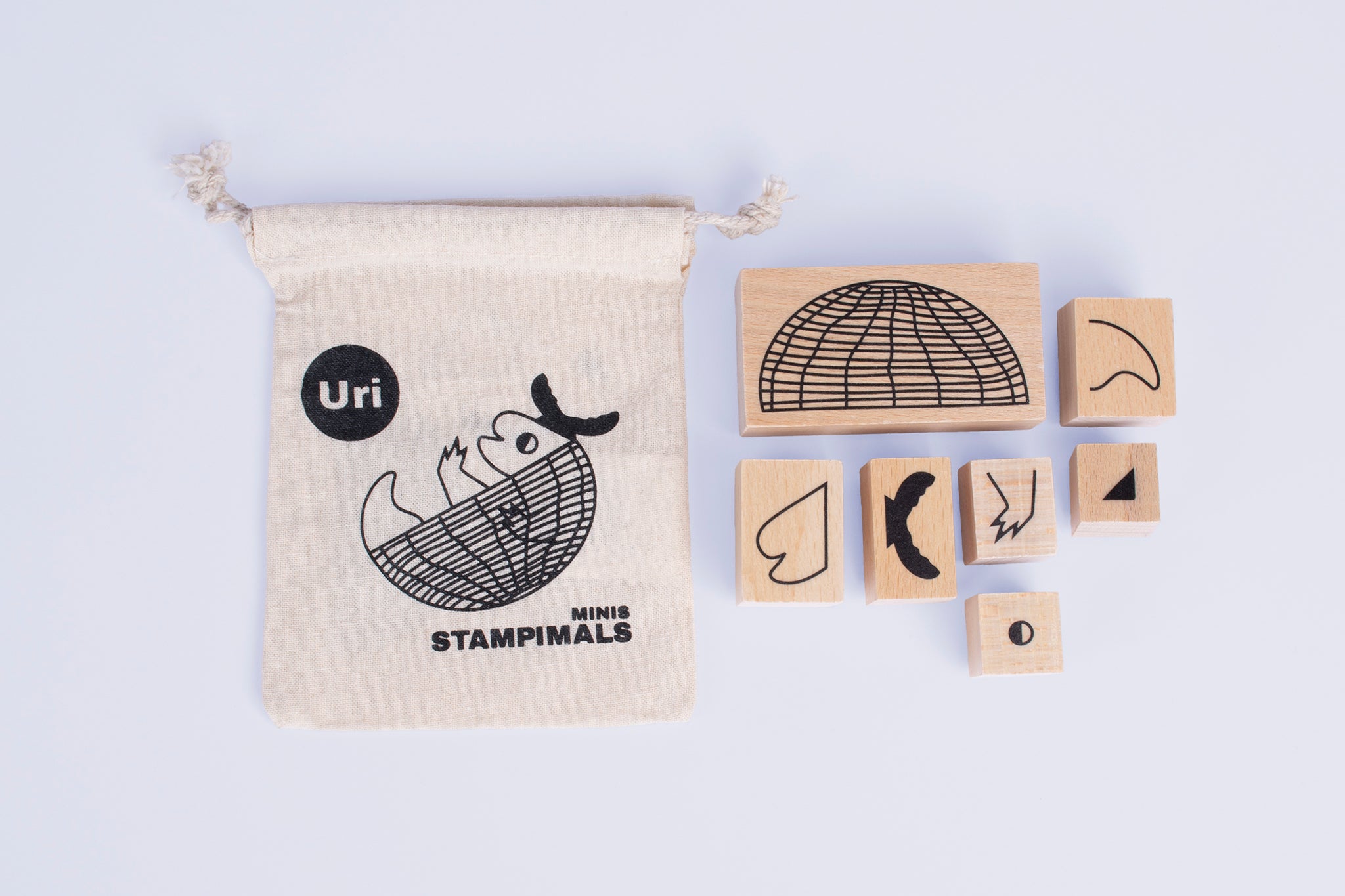 Bedrucktes Baumwollsäckchen mit sieben ausgepackten Holzstempeln daneben.